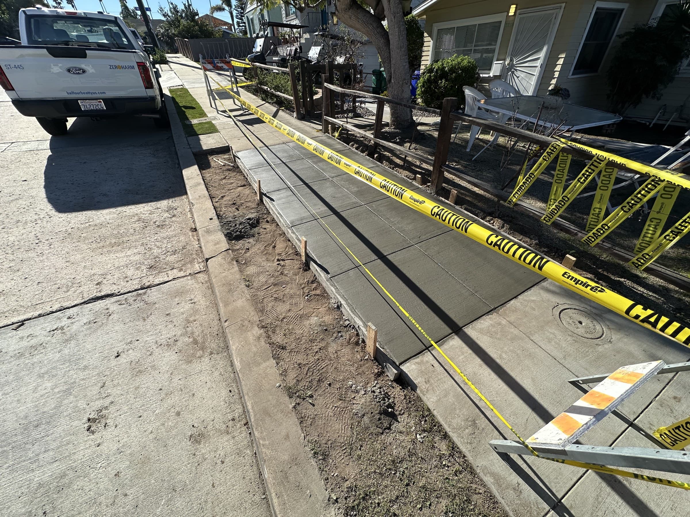 Freshly poured concrete sidewalk roped off with caution tape