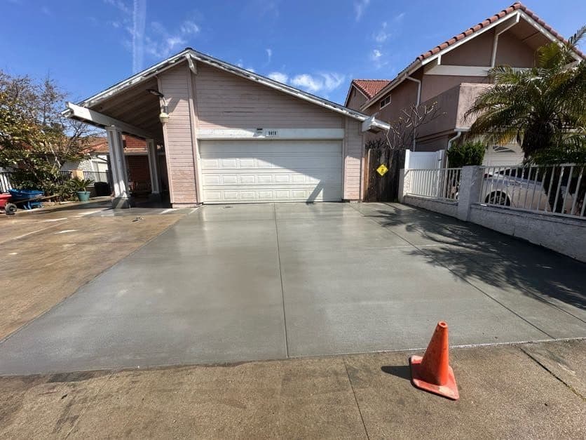Completed concrete driveway framed by palm trees