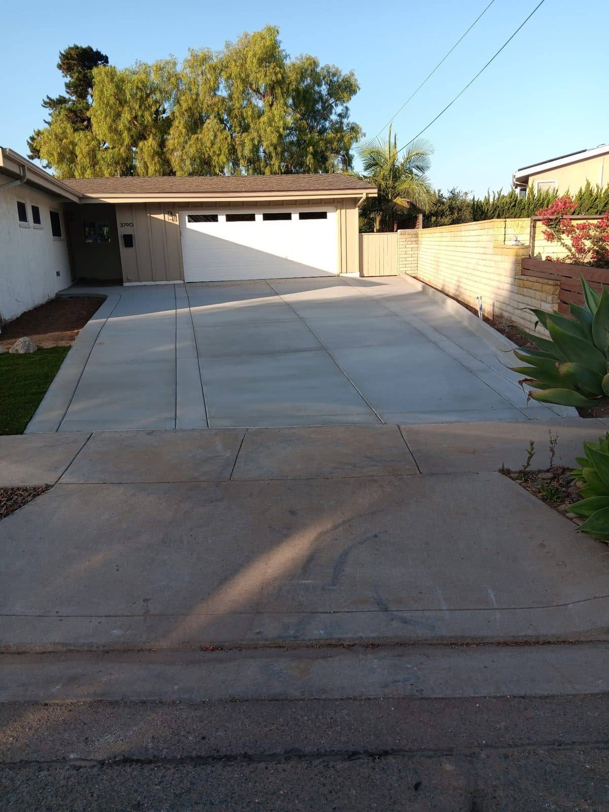 Long concrete driveway leading to a detached garage