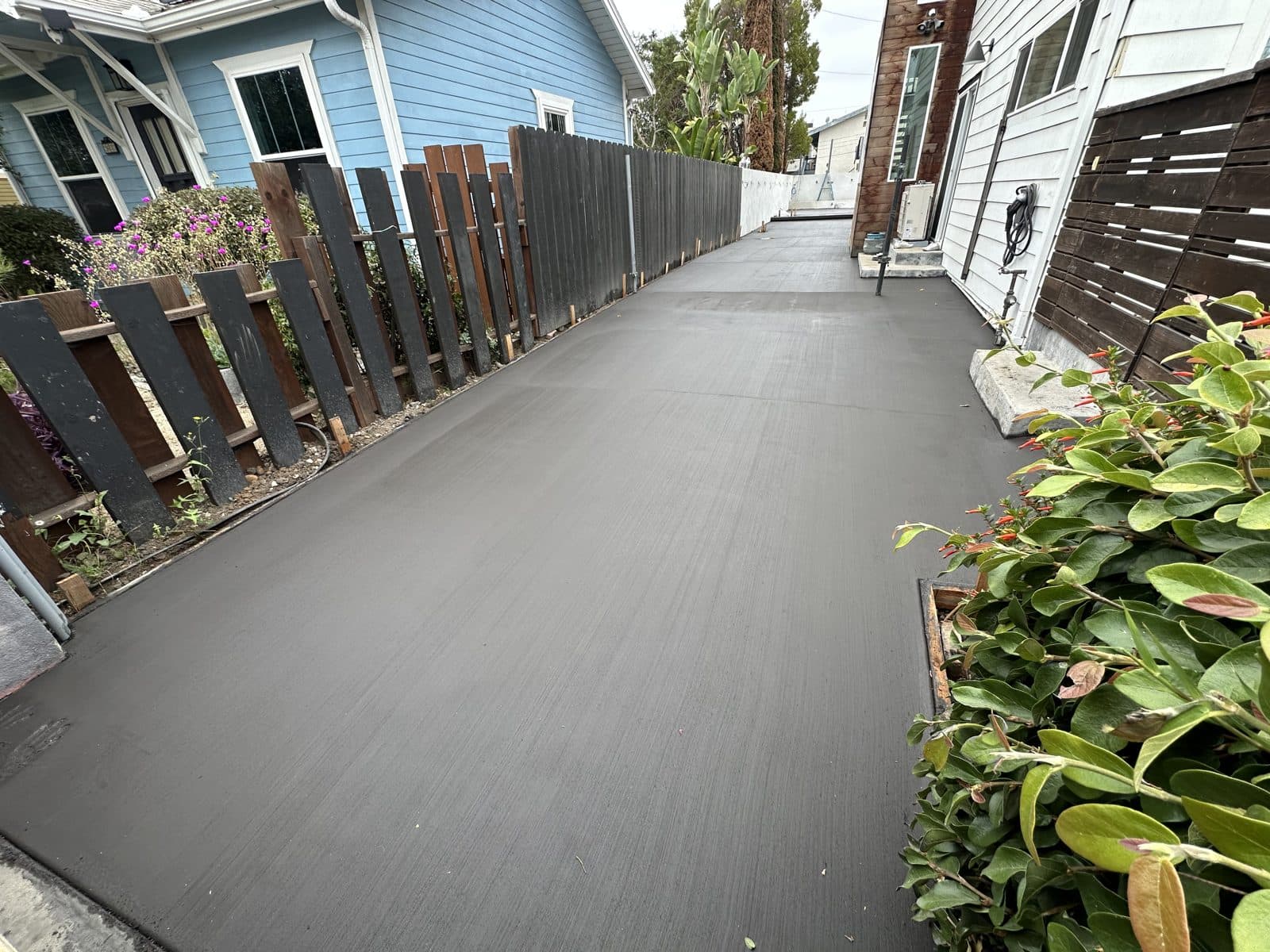 New side-yard concrete driveway between two San Diego homes