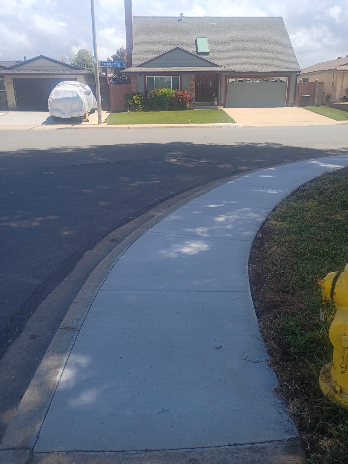 Freshly poured curved concrete sidewalk wrapping a street corner