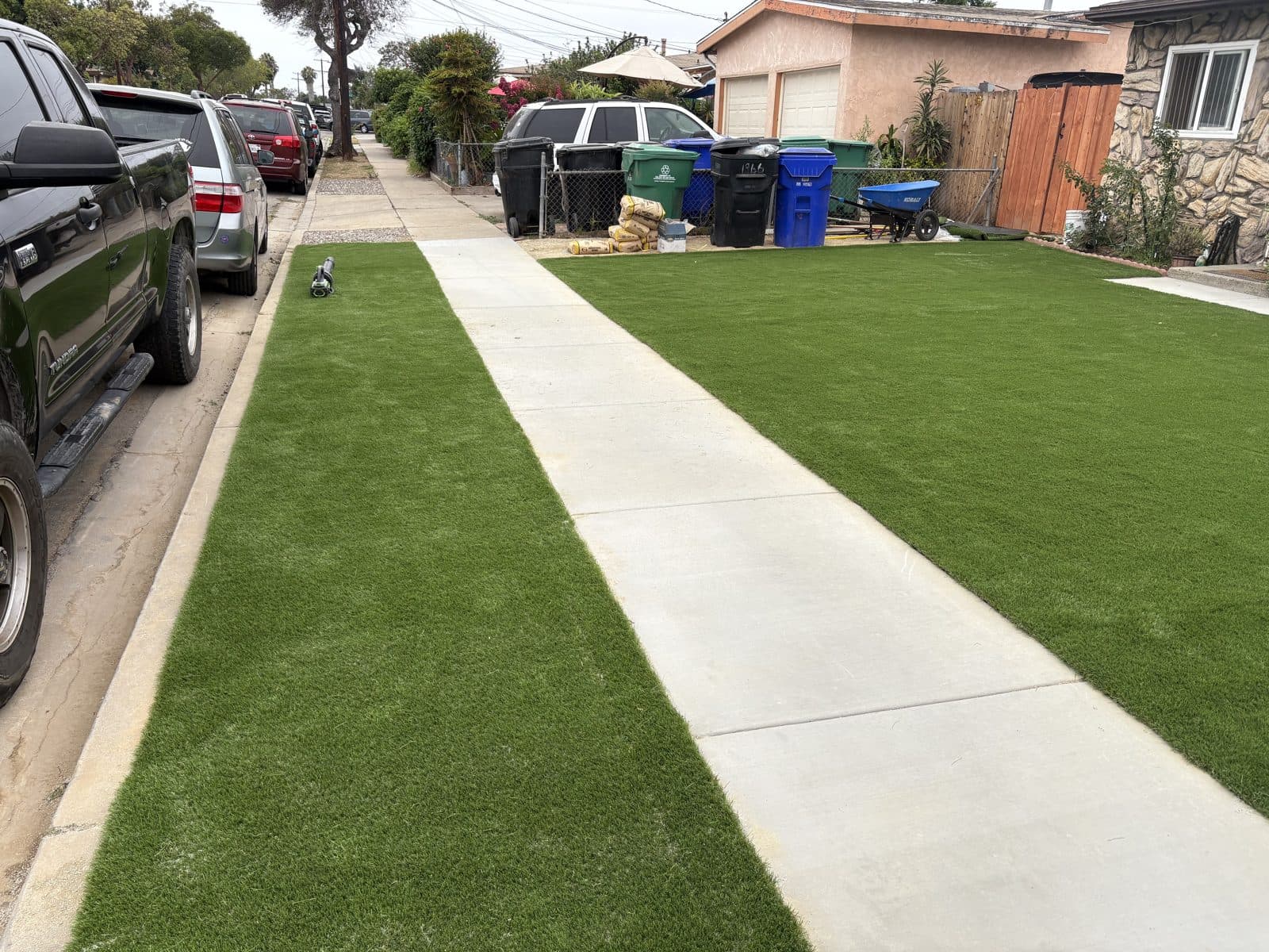 Two new concrete walkways bordered by fresh artificial turf